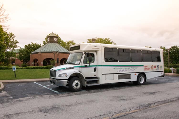 Westmoreland Transit bus in a parking lot with business buildings in the background.